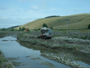 Digger and dumper transporting gravel for new river