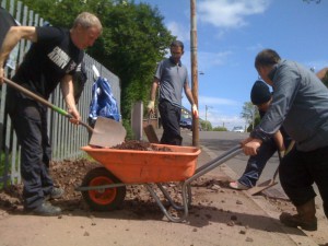 People filling a wheelbarrow