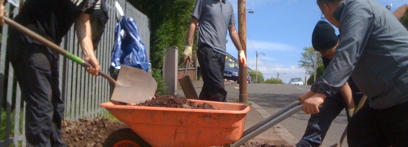 People filling a wheelbarrow